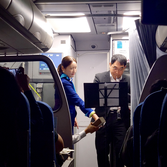 15일 에어부산 부산~다낭 항공편에서 시행된 기내 특별 연주회에서 장애인 오보이스트가 연주하고 있다. 에어부산 제공